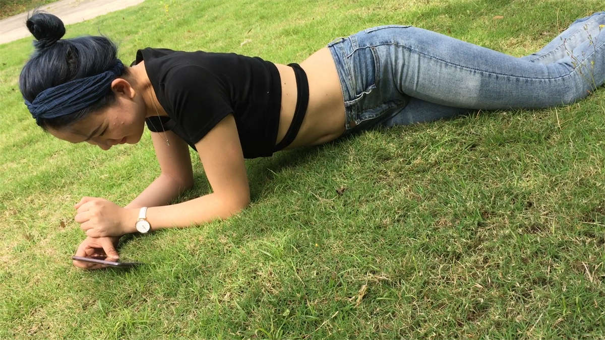 草地上紧身牛仔美眉-日更街拍