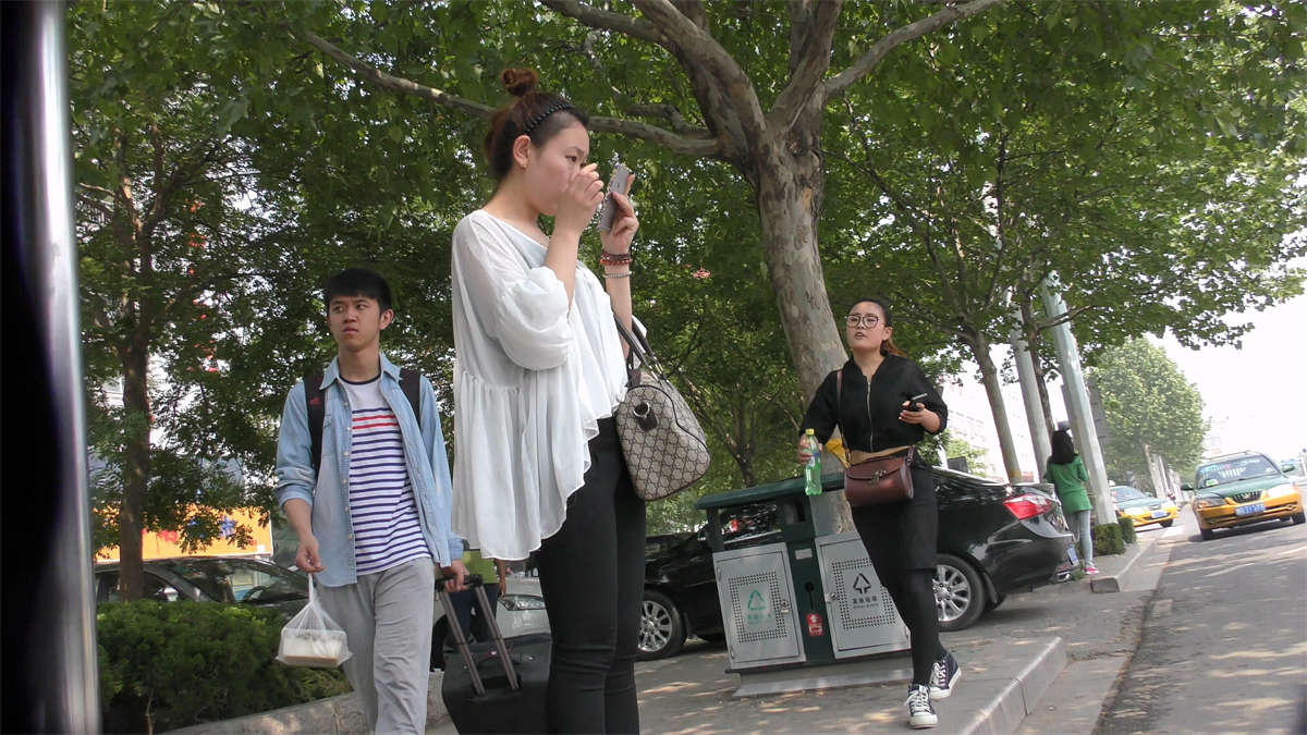 对着镜子整理容装的小美女-日更街拍