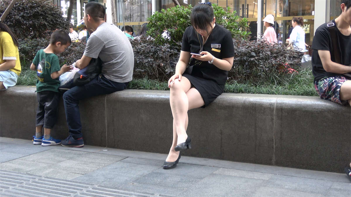 花圃边玩手机的制服街拍美女-日更街拍