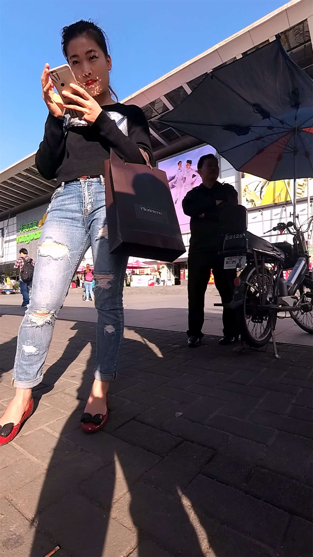 紧身破洞牛仔裤黑色毛衣美女等公交车-日更街拍