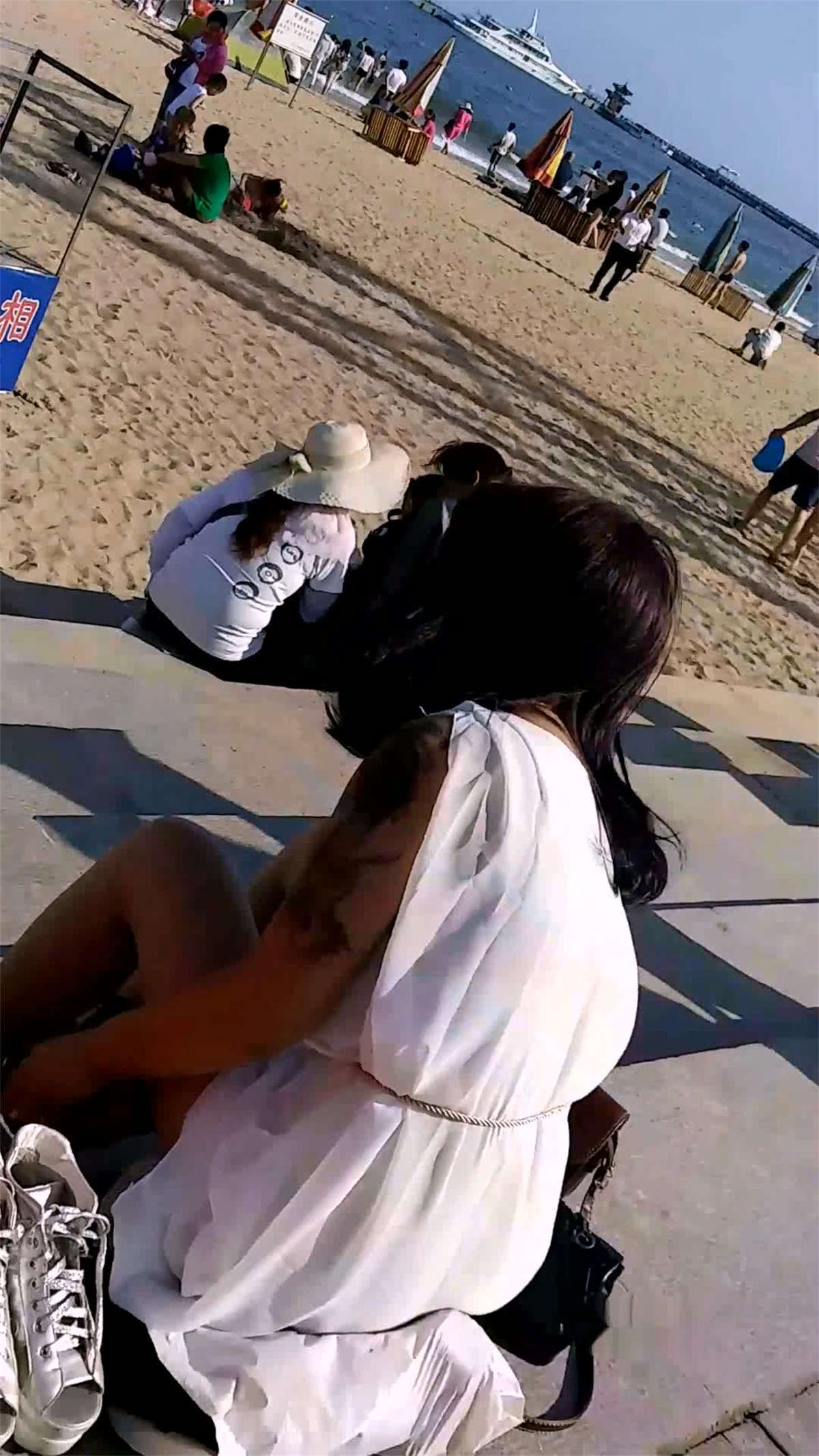 图片[2]-海滨沙滩上的小美女在换丝袜-日更街拍