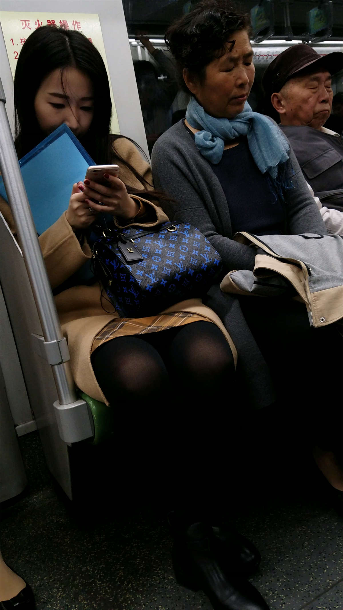 图片[2]-地铁玩手机的米色外套黑色丝袜OL美眉-日更街拍