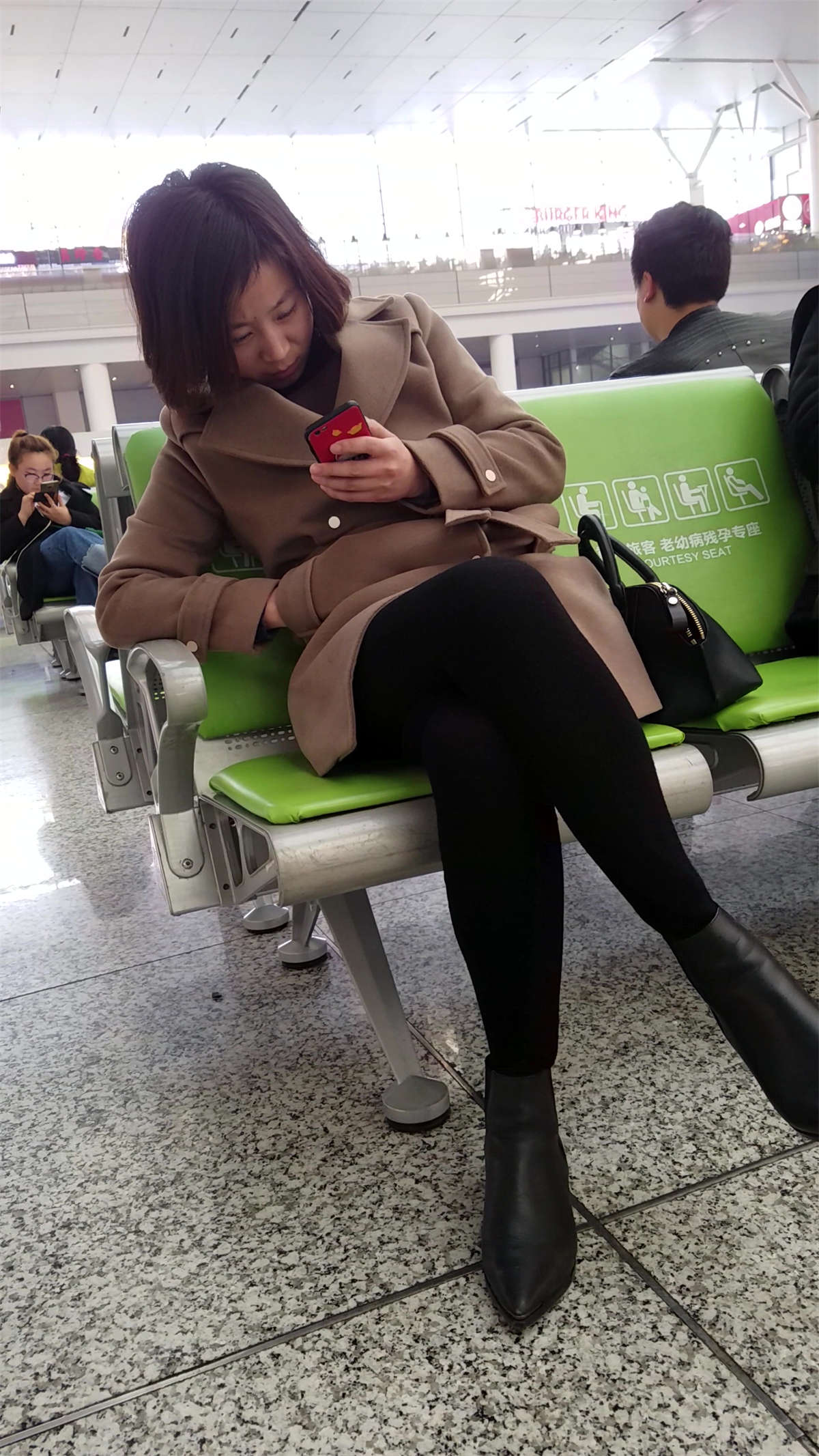 [4K高清视频]候车室的黑色打底裤美眉低头玩手机-日更街拍